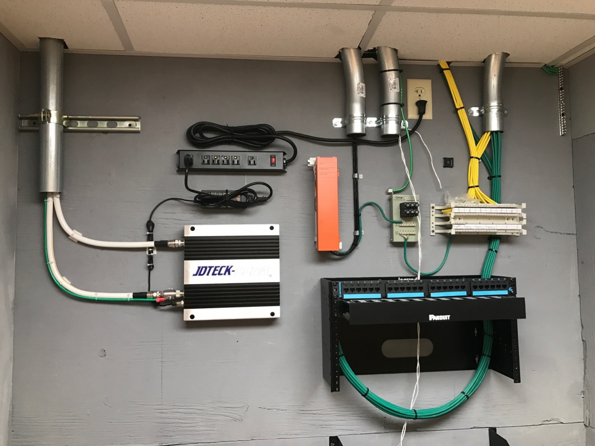 Consumer grade quad band repeater installed in comm room. JDTECK ensures that all approved techs maintain the highest quality standards when completing a system deployment.